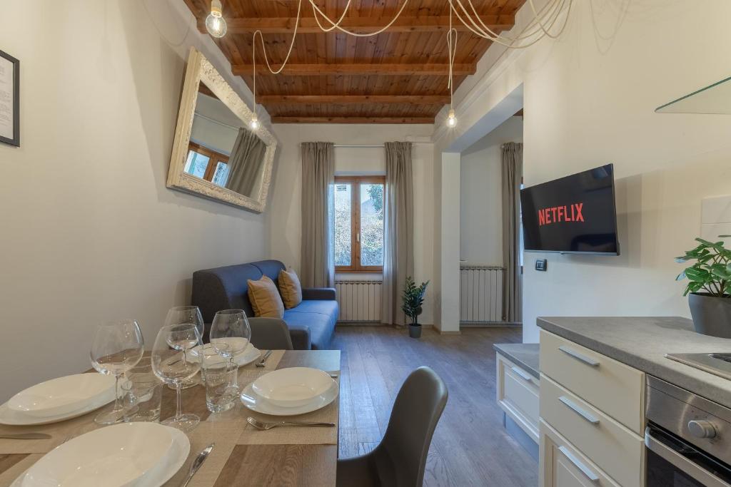 a kitchen and living room with a table with wine glasses at Charming Apartment 18 min da Firenze in Prato