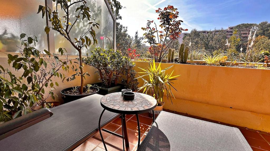 d'un balcon avec une table et des plantes en pot. dans l'établissement Dolce Vacanza, à Nice