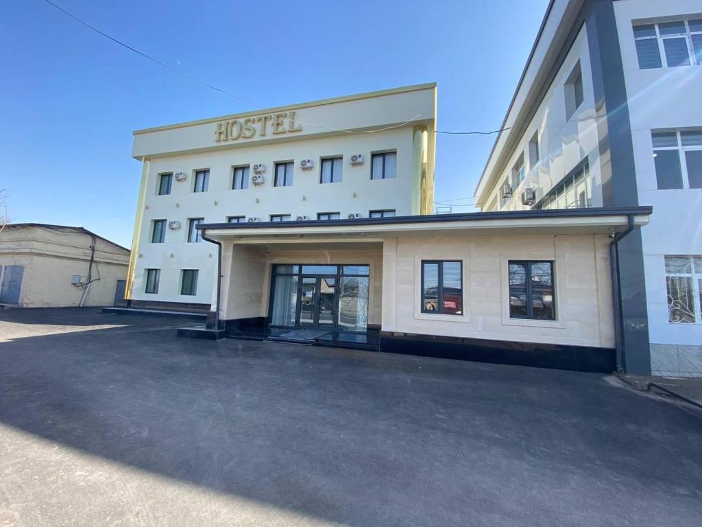 Hostel 1001 Noch في طشقند: مبنى ابيض كبير عليه لافته