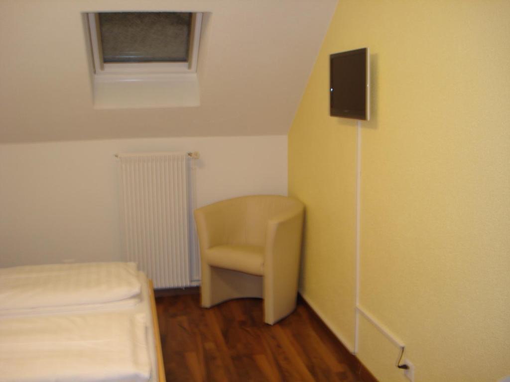 a small room with a chair and a window at Hotel Gregory in Zürich