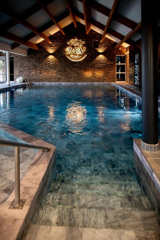 a pool of water in a room with a brick wall at M&V Resort Camping in Langrune-sur-Mer