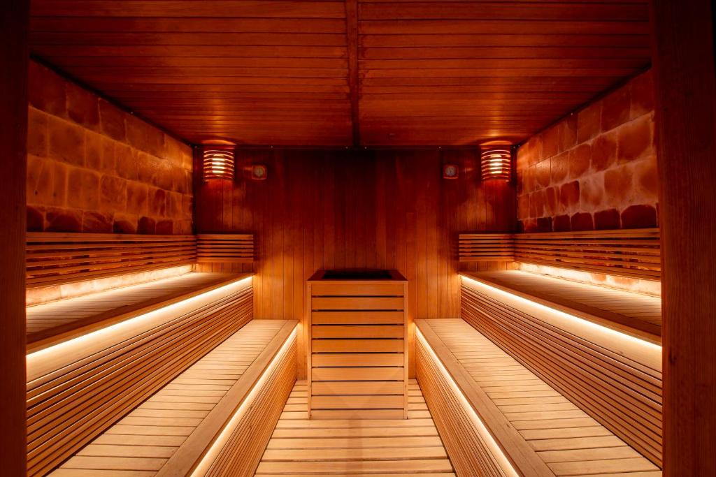 an empty sauna with wooden walls and wooden benches at M&V Resort Camping in Langrune-sur-Mer
