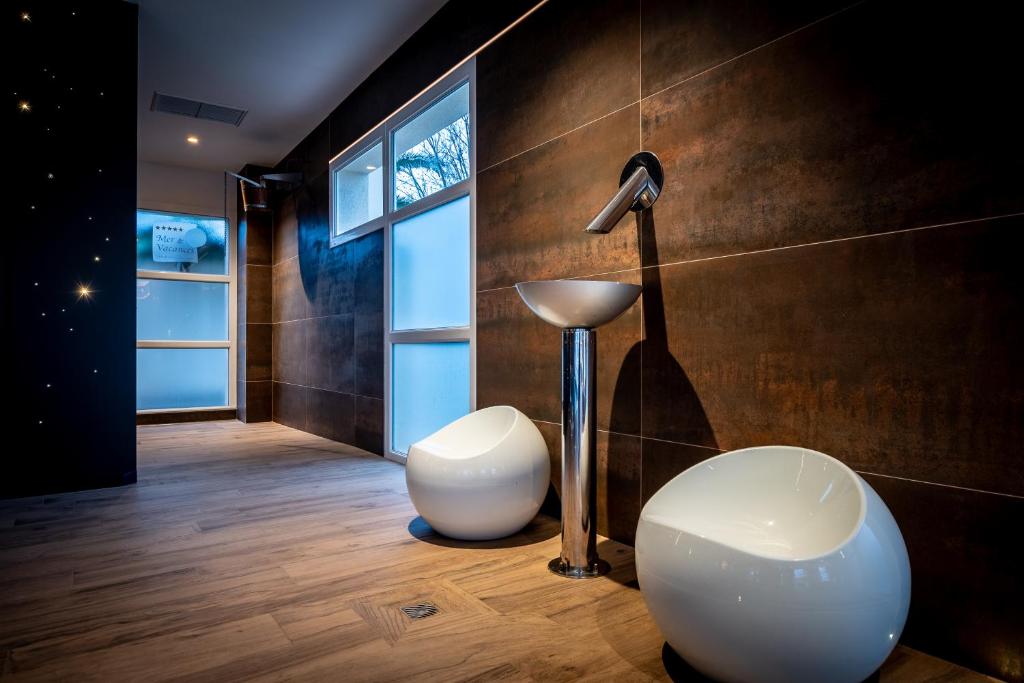 a bathroom with a lamp and a white stool at M&V Resort Camping in Langrune-sur-Mer