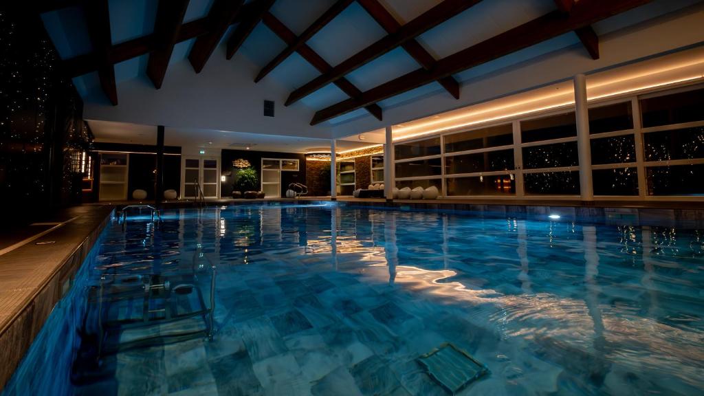 a swimming pool in a hotel at night at M&V Resort Camping in Langrune-sur-Mer