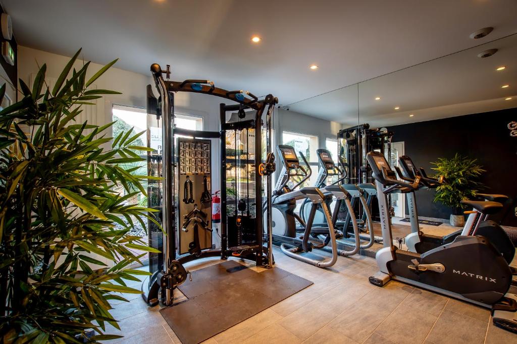 a gym with several treadmills and elliptical machines at M&V Resort Camping in Langrune-sur-Mer