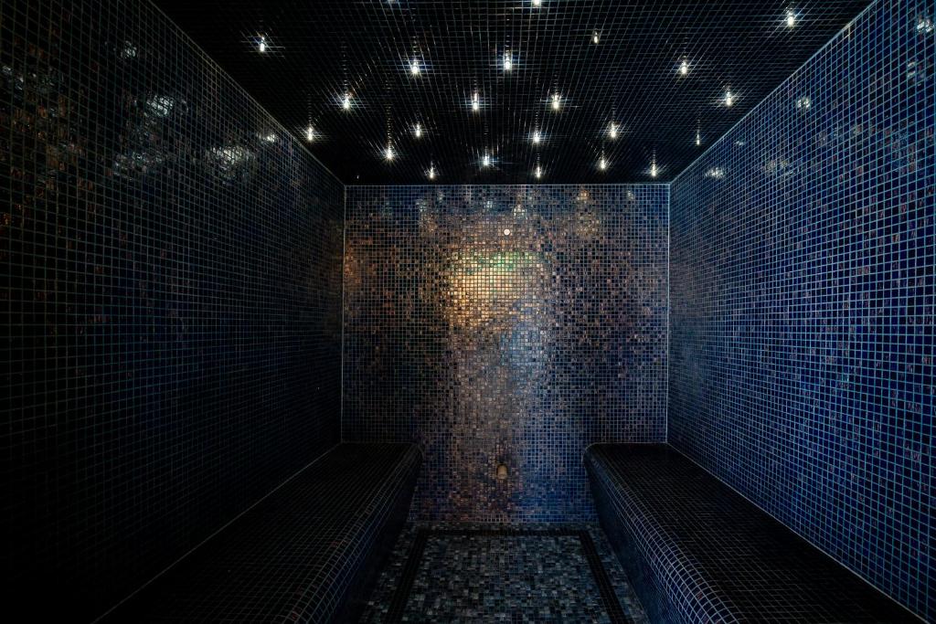 a dark room with benches and lights on a wall at M&V Resort Camping in Langrune-sur-Mer