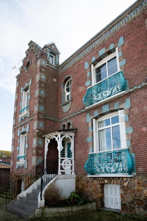 un vieux bâtiment en briques avec une tour d'horloge. dans l'établissement Villa Zachee - maison familiale & parking gratuit, au Tréport