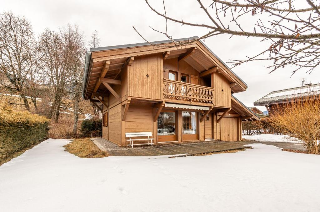 une maison en rondins dans la neige dans l'établissement SmartStay Chalet Diamant - Praz-sur-arly, à Praz-sur-Arly