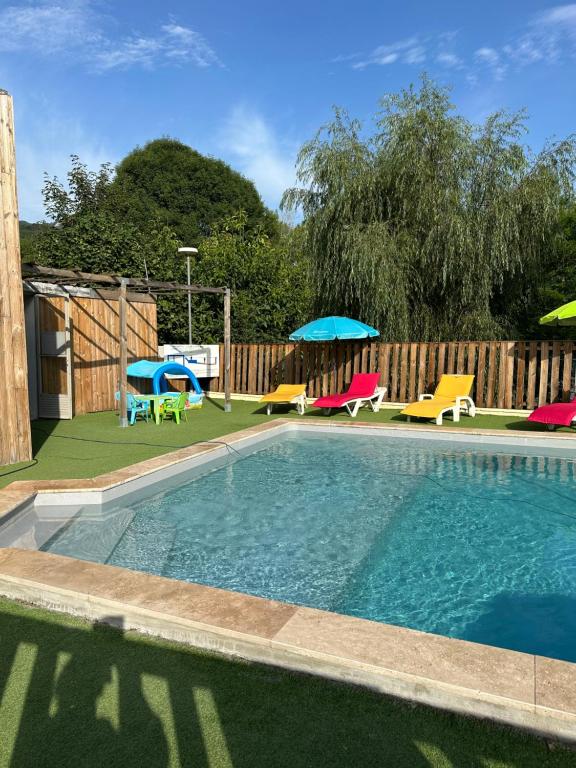 une piscine avec chaises et parasols dans une cour dans l'établissement Camping L Eden Road, à Castellane