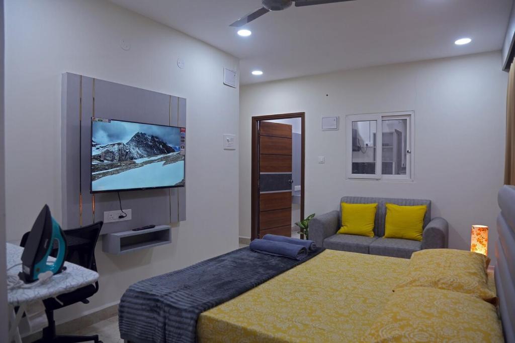 a bedroom with a bed and a flat screen tv at Yendluri's -Studio Flat 1BHK -Kondapur, Gachibowli in Lingampalli