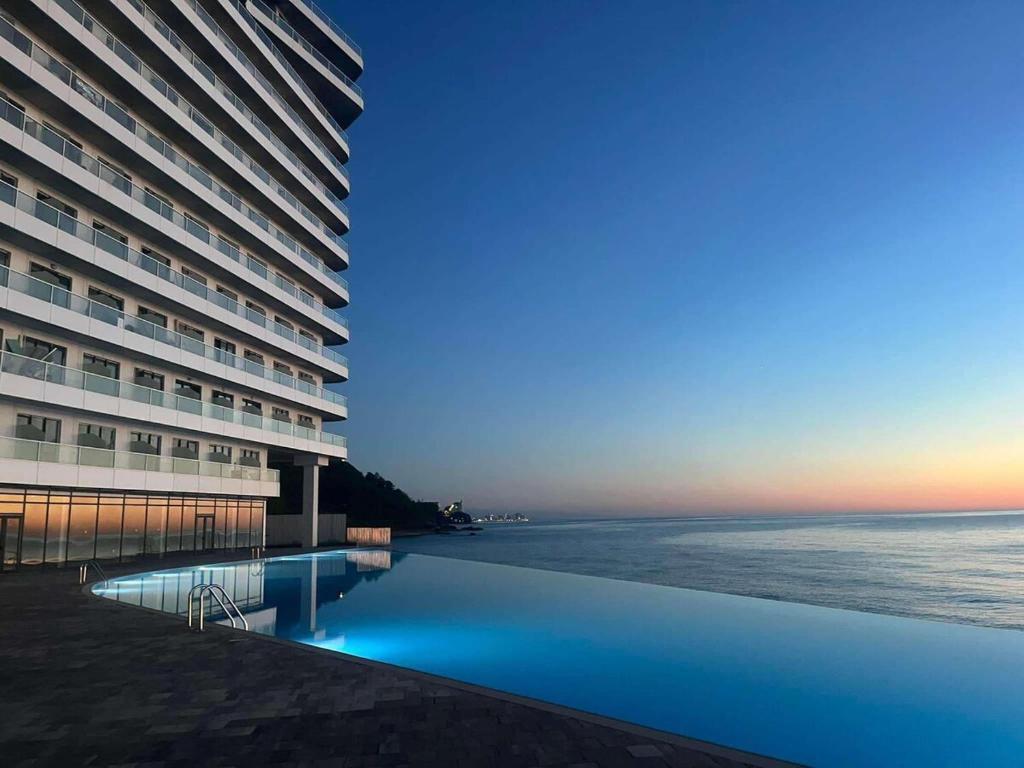 un hôtel avec une piscine à côté de l'océan dans l'établissement Bamboo Beach Tsikhisdziri, à Tsikhisdziri