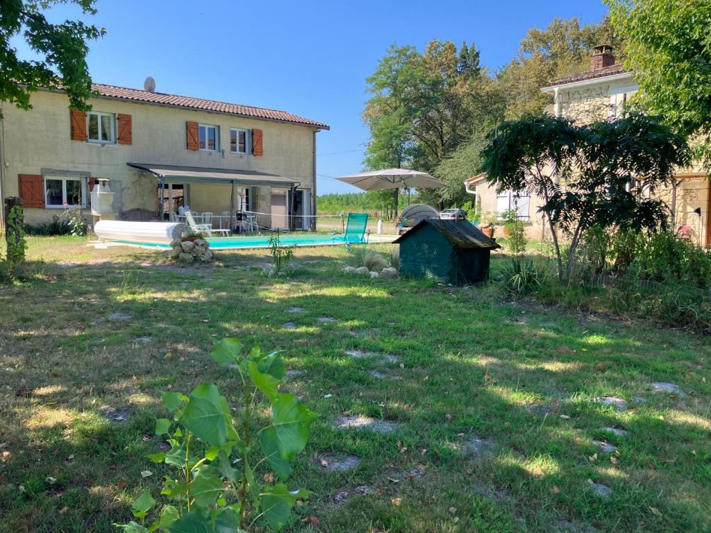 une cour avec une maison et une baignoire en face de celle-ci dans l'établissement Maison avec piscine dans airial Landais, à Cudos