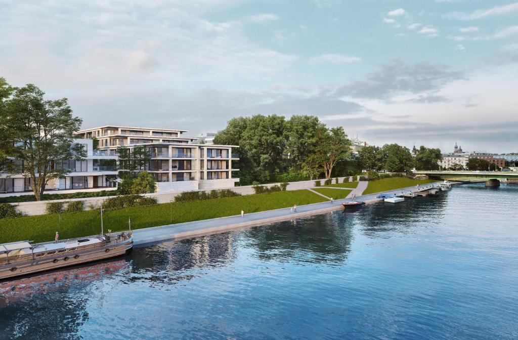 Un río con barcos en él con edificios en el fondo en Wawel View Stylish Apartment - Kościuszki 22, en Cracovia
