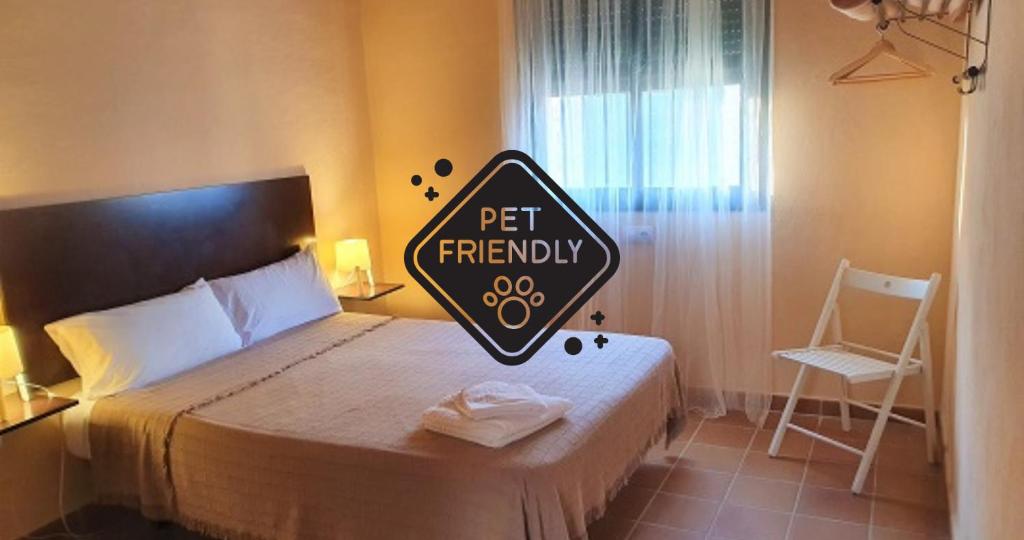 a bed with a sign that reads pet friendly at Alojamiento Rural Flamingo in El Rocío