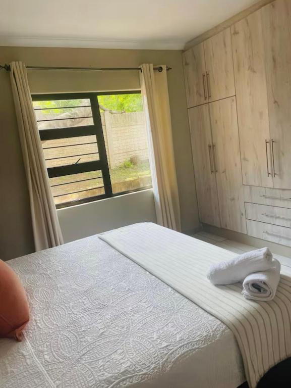 a bedroom with a large bed with a window at SnaMel's in Waterfall