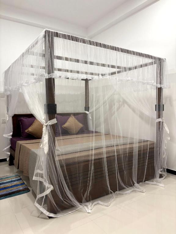 a bed with a canopy in a room at Heaven's Edge Lodge & Spa in Weligama
