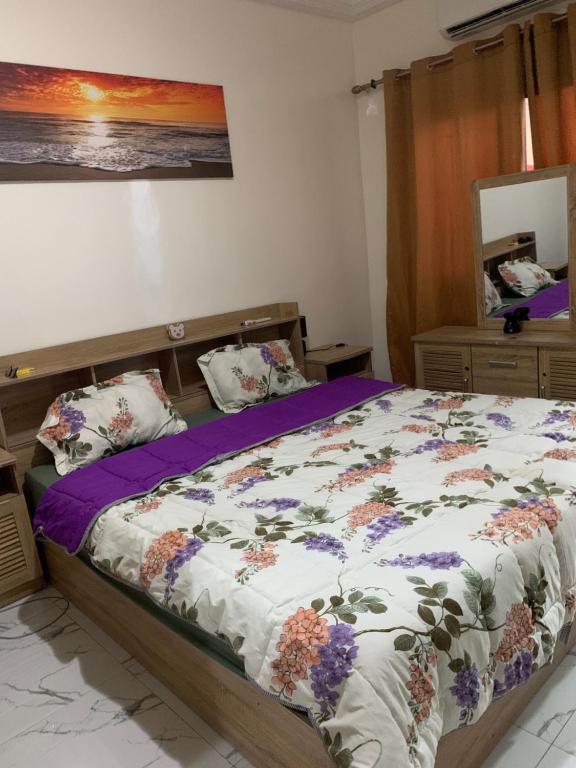 una camera da letto con un letto con piumone e cuscini di Teranga Haven a Dakar