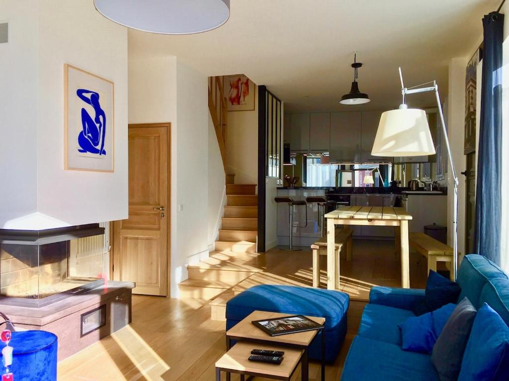 un salon avec un canapé bleu et une cuisine dans l'établissement LaBoucherieTrouville Maison 200m2 5 Chambres HyperCentre Trouville 13 pers plus bébés,, à Trouville-sur-Mer