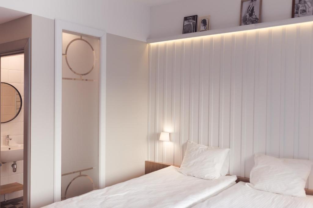 una camera bianca con 2 letti e uno specchio di Rannahotell a Pärnu