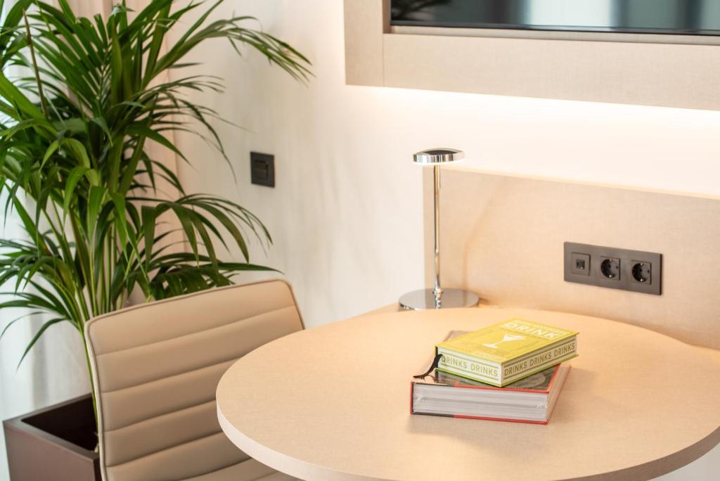a table with books on it with a plant at INNSiDE by Meliá Tenerife Santa Cruz in Santa Cruz de Tenerife