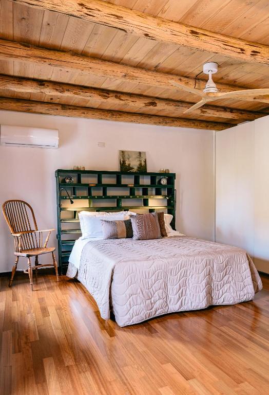 a bedroom with a large bed and a chair at Villa Hermes in Costermano