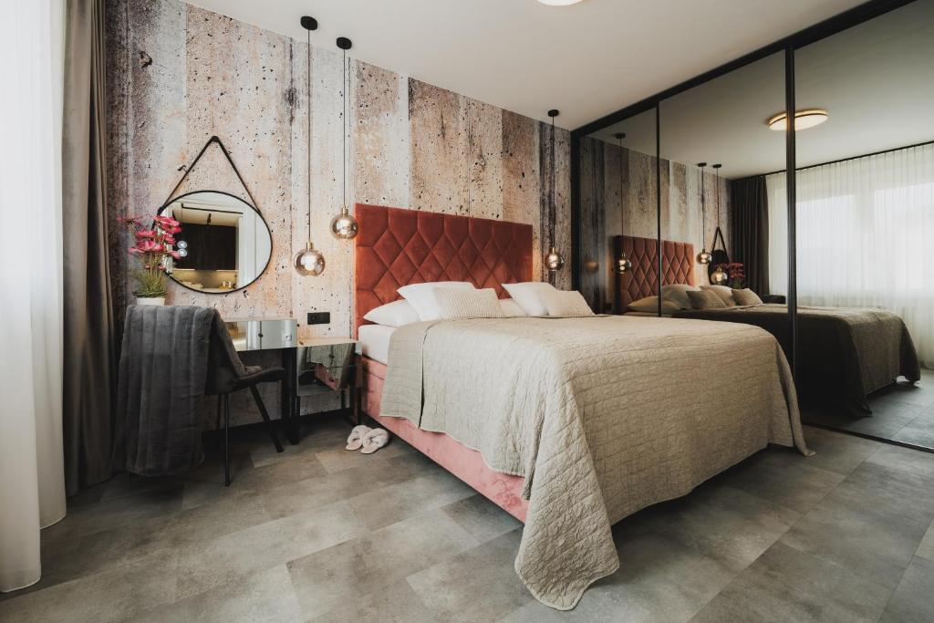 a bedroom with a bed and a desk and a mirror at ROSE LUXURY APARTMENT & 24h self check-in with private parking in Banská Bystrica