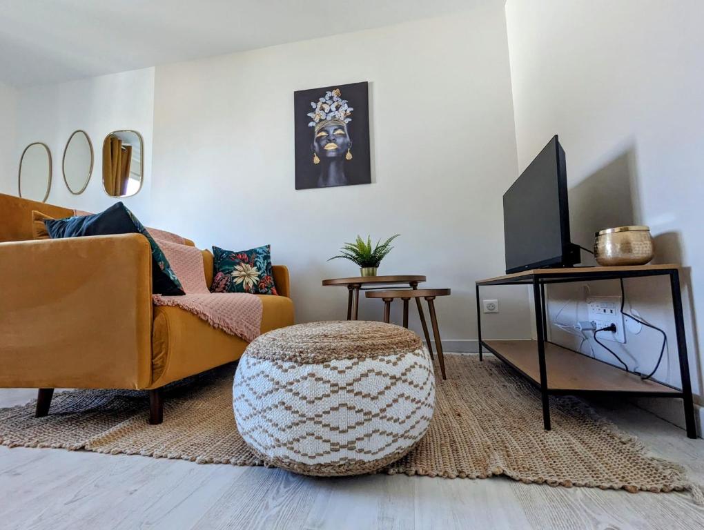 un salon avec un canapé et une télévision dans l'établissement Room Nest, à Bayonne