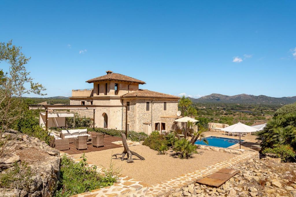 a building with a swimming pool and a house at Finca Estrella in Artá