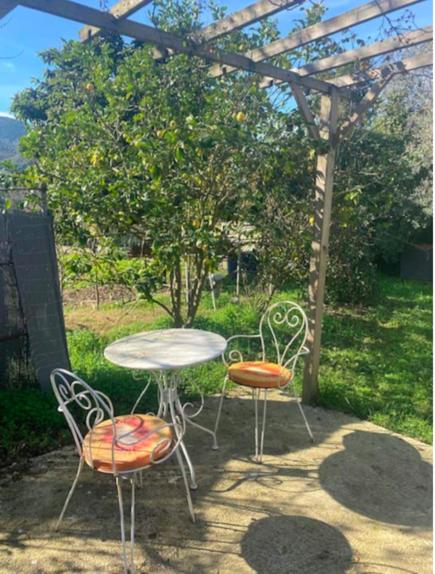 trois chaises, une table, une table et des chaises sous une pergola dans l'établissement Maison individuelle type F2, à Alata