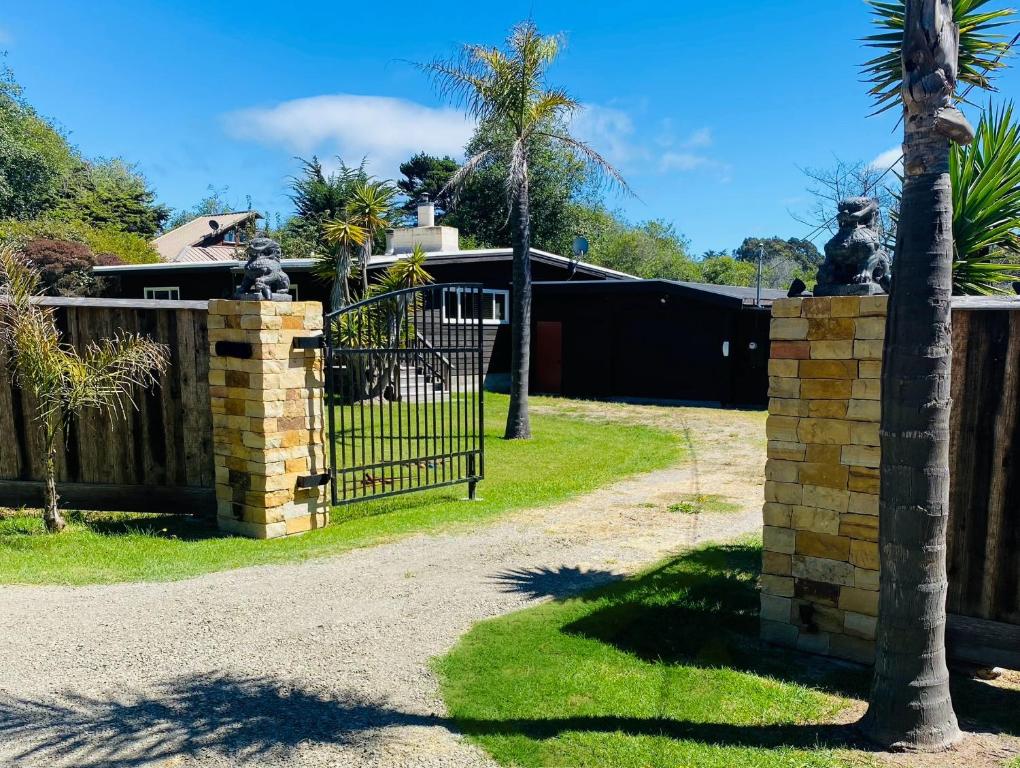 a gate in front of a house with a palm tree at Pacific Sands Vacation Home in Fort Bragg