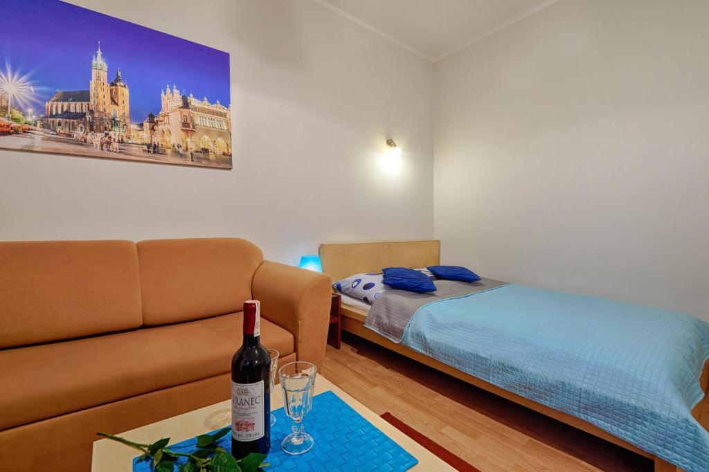 una sala de estar con un sofá y una cama en Libro Rooms, en Cracovia