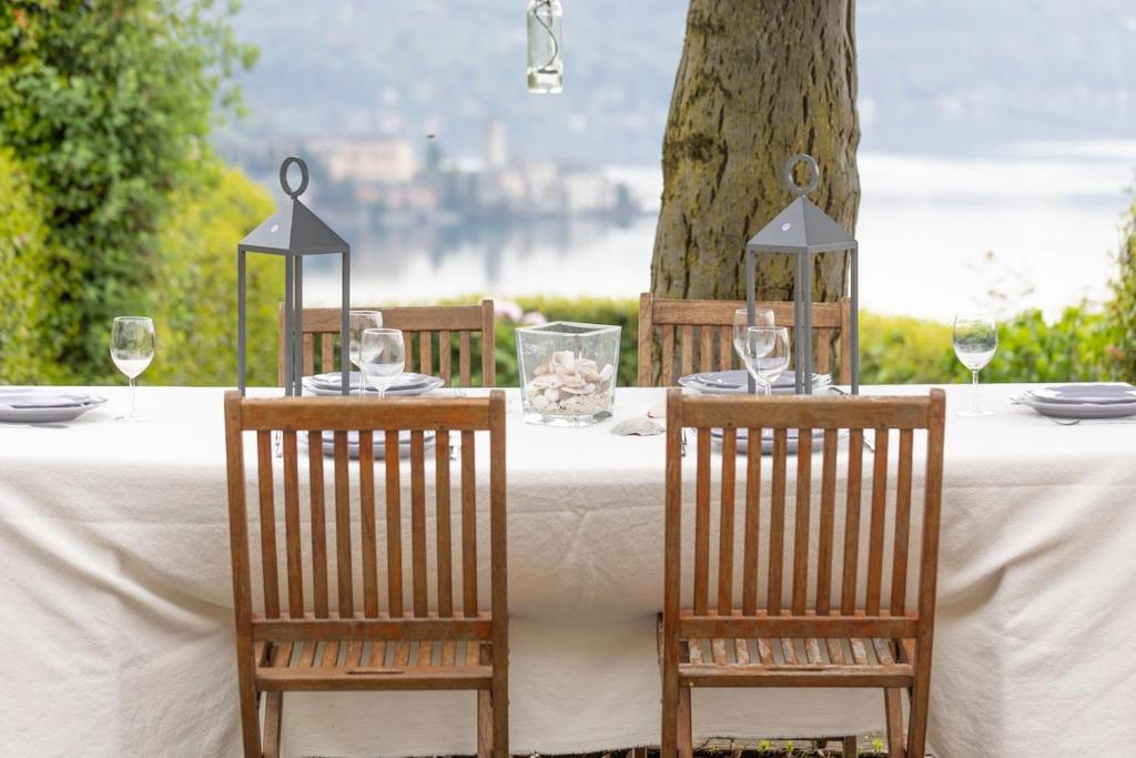 - une table avec deux chaises et une table avec des verres à vin dans l'établissement Villa Petrarca, Luxury villa with spectacular views on lake Orta, à Pella