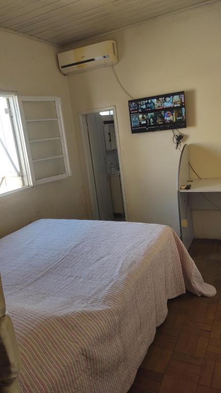 a bedroom with a bed and a sink and a window at Posada Dale Dale in São Gabriel