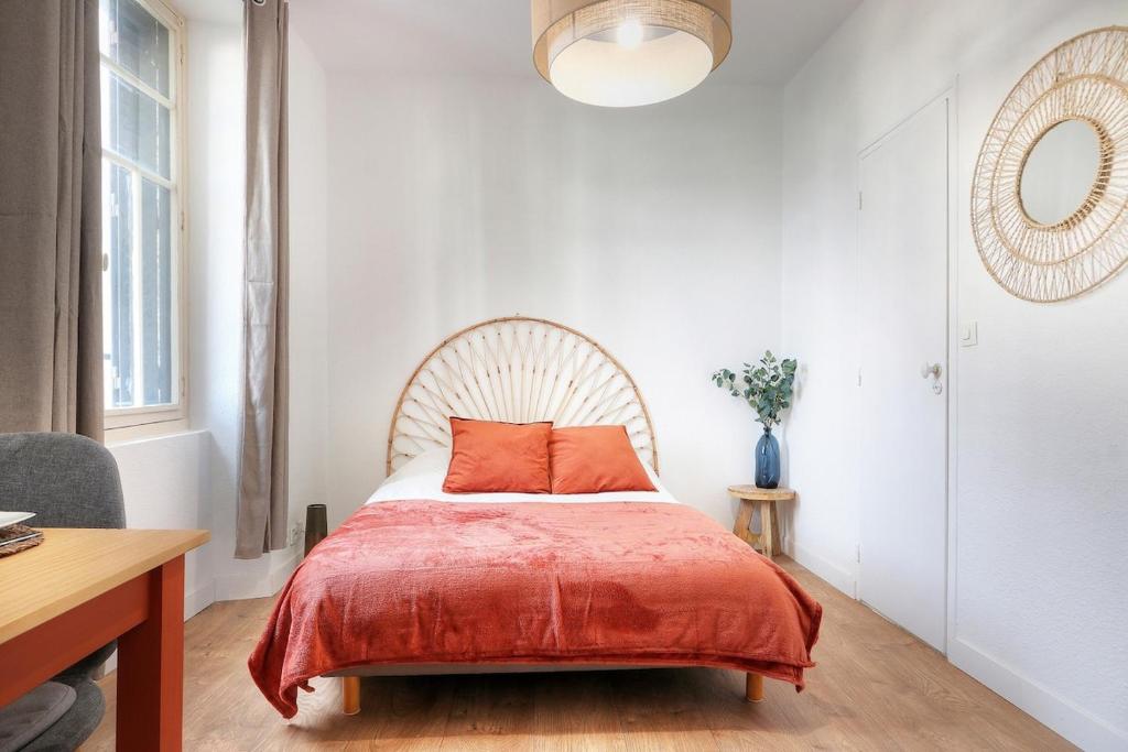 une chambre avec un lit avec une couverture rouge dans l'établissement Studio Ambre, à Rennes