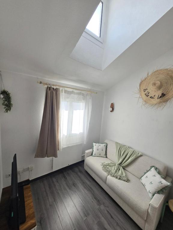 un salon avec un canapé et une fenêtre dans l'établissement Le duplex, à Bussy-Saint-Georges