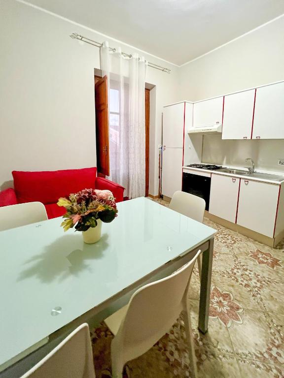 a kitchen with a white table and a red couch at Casa La Saletta in Torrenova