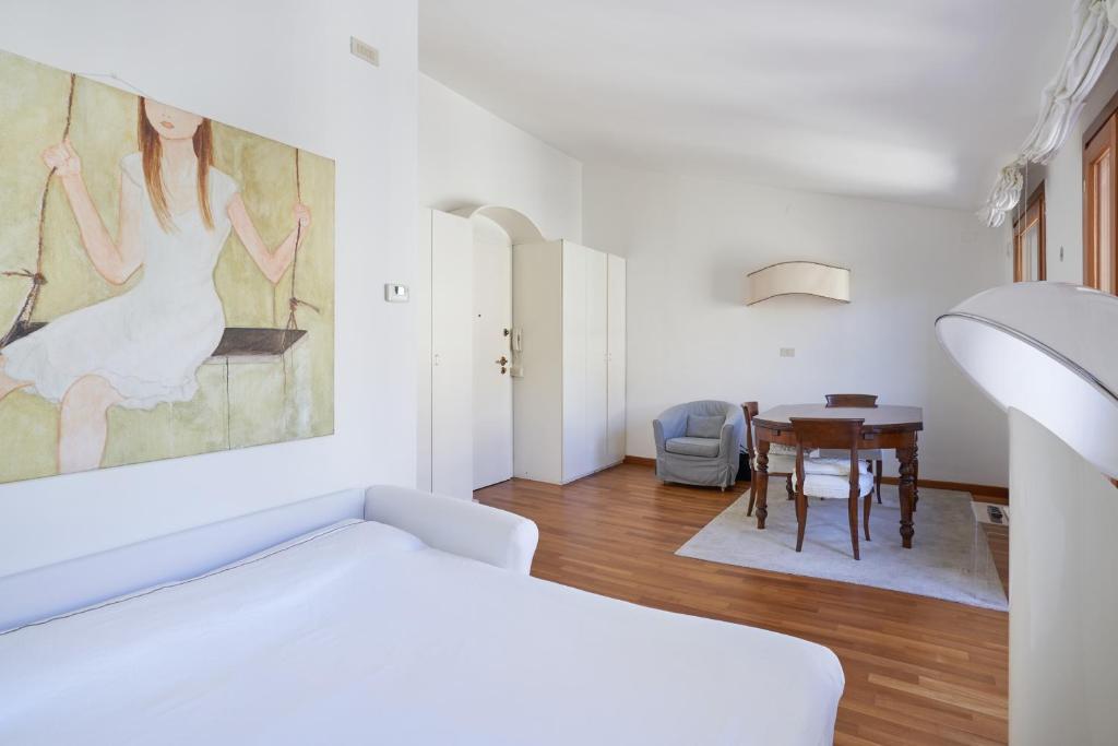 Casa Ambra la tranquillità in centro città في بادوفا: غرفة بيضاء مع سرير وطاولة