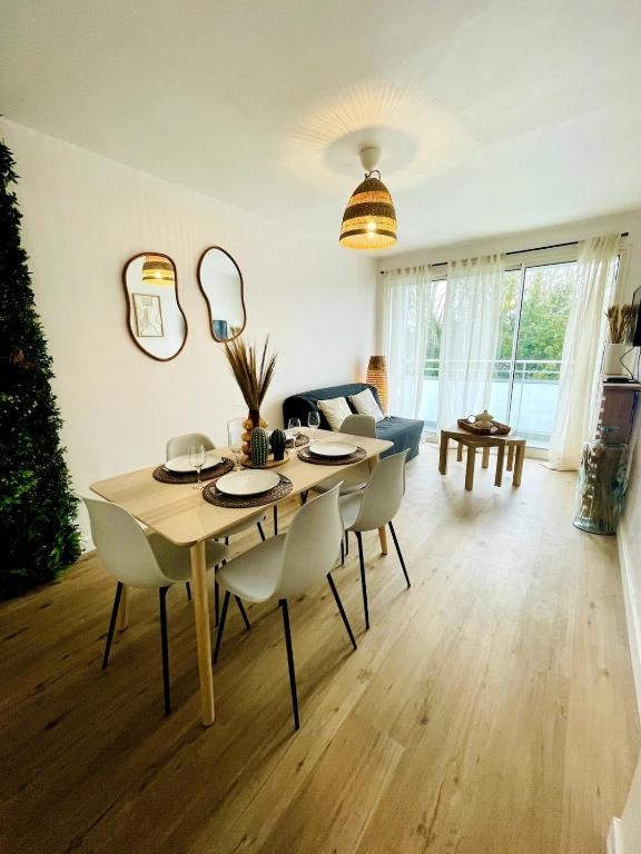 - une table à manger et des chaises dans le salon dans l'établissement Le Jamot - Proche ville, à La Rochelle