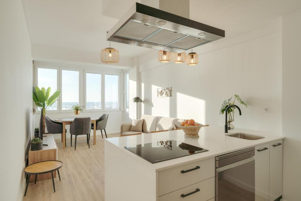 a kitchen and living room with a table and chairs at Paraiso vista Incrivel in Costa da Caparica
