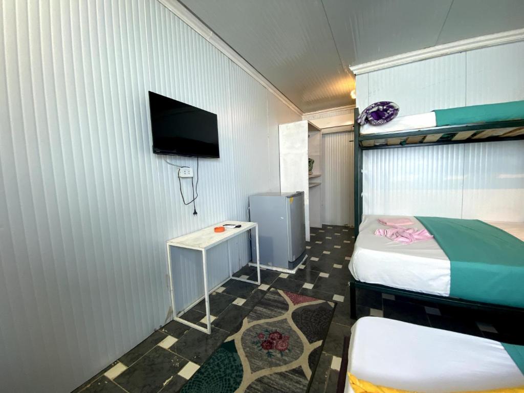 a small room with a bed and a tv at Octopus Hotel in Dahab