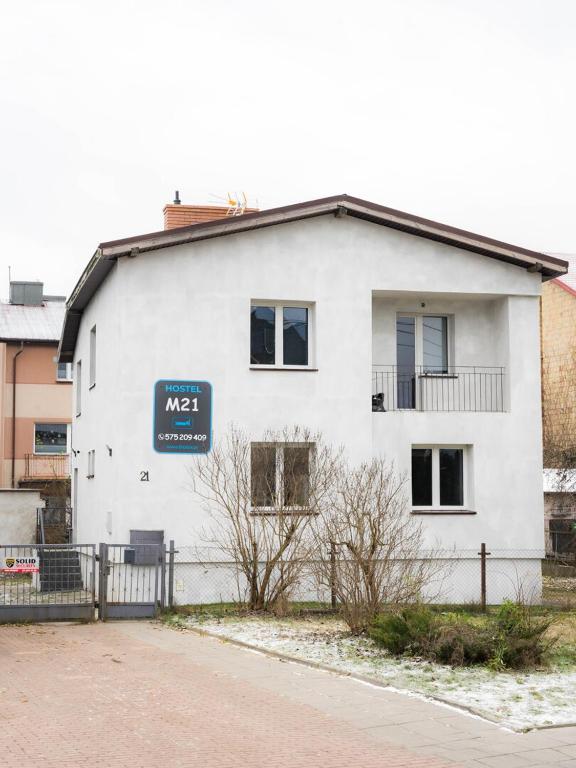 a white building with a sign on the side of it at Noclegi M21 in Białystok