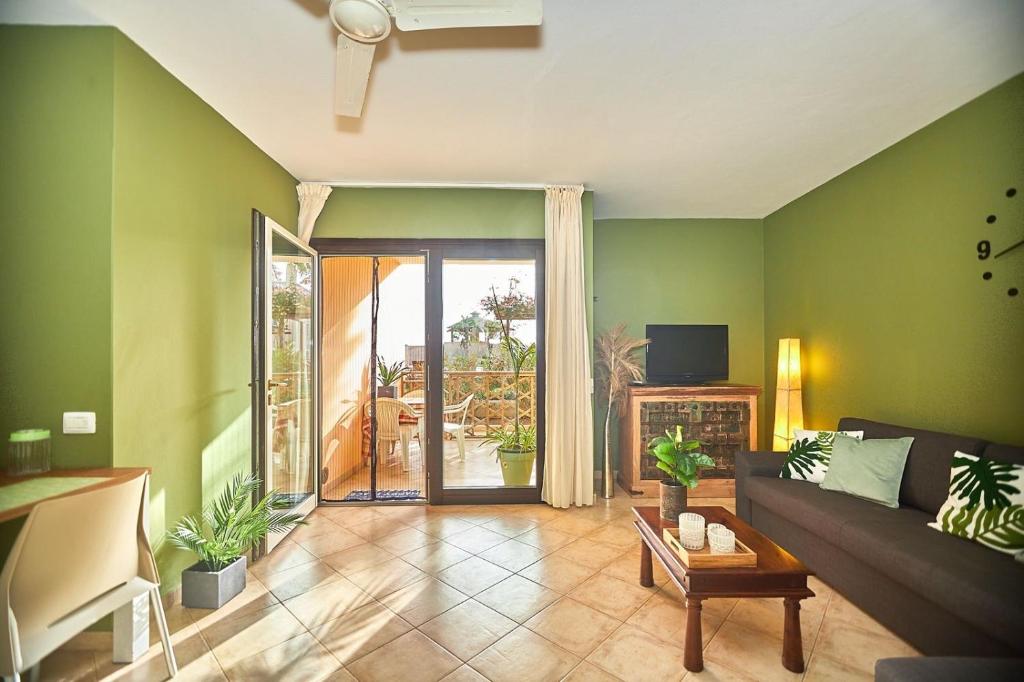 een woonkamer met groene muren en een bank bij Tropical Casa Verde Santa Maria in Santa Maria