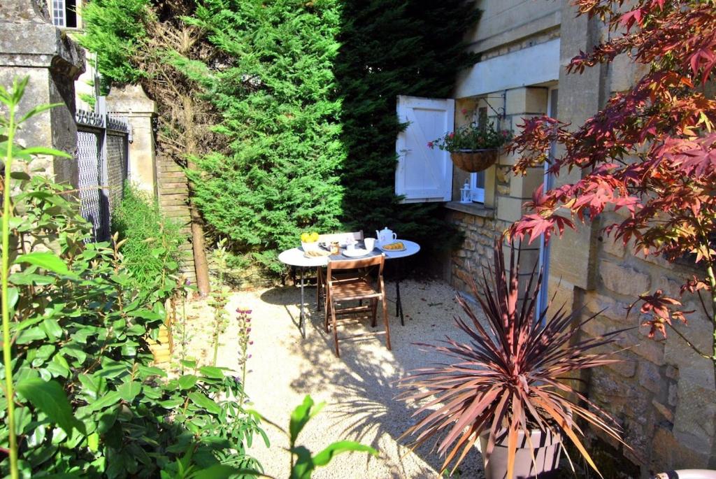 d'une terrasse avec une table et des chaises dans le jardin. dans l'établissement A 5mn à pieds du centre historique de Sarlat, à Sarlat-la-Canéda