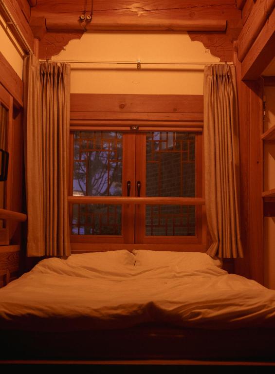 Postel nebo postele na pokoji v ubytování Yeoyeoje - Hanok Accommodation with the atmosphere of Hwaseong Fortress Road in Suwon, a UNESCO World Heritage