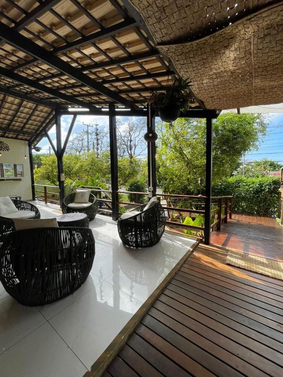a patio with chairs and tables on a deck at Pousada Aventurine Noronha in Fernando de Noronha
