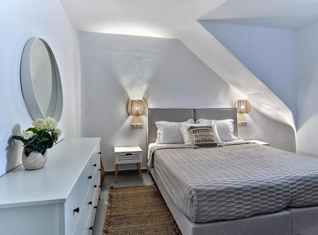 een witte slaapkamer met een bed en een spiegel bij Paros Iconic Apartments in Kampos Paros