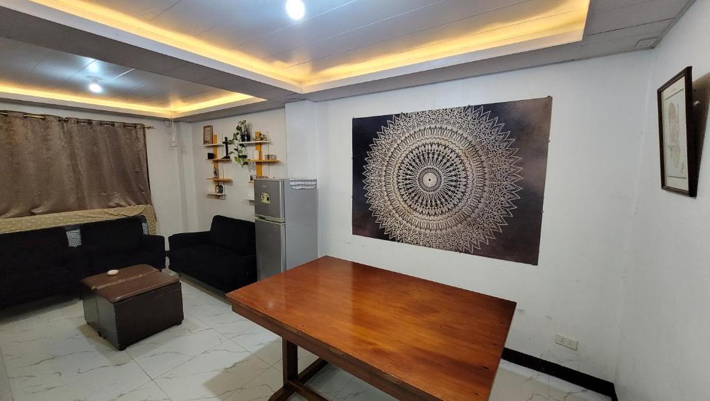 a living room with a table and a refrigerator at Cozy Casa in the City Center in Baguio