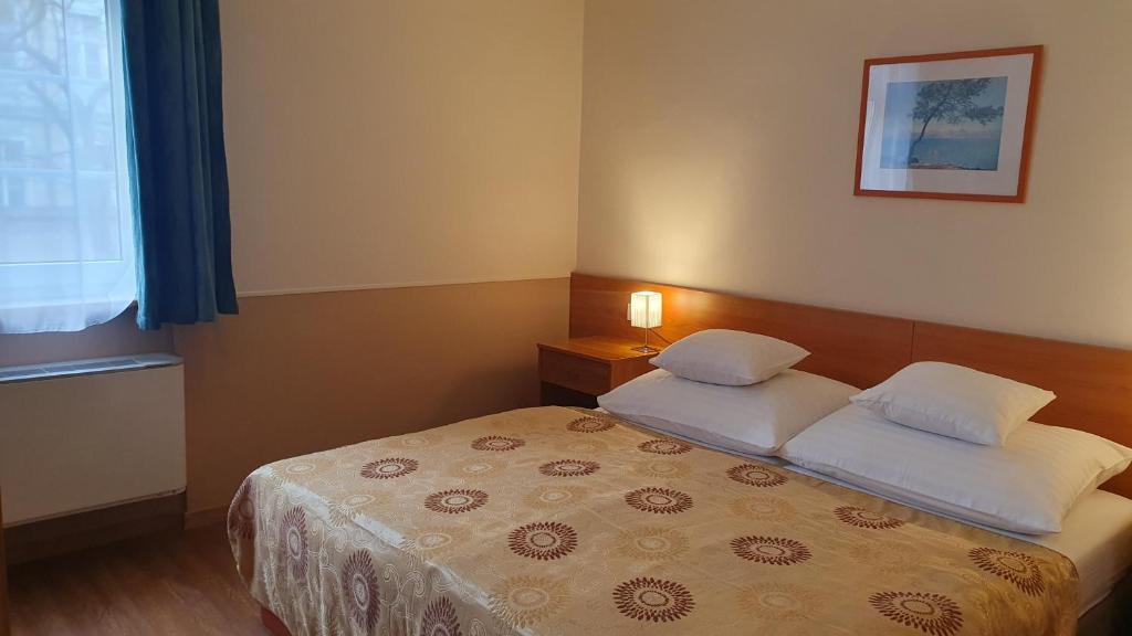 Łóżko lub łóżka w pokoju w obiekcie Hotel Baross
