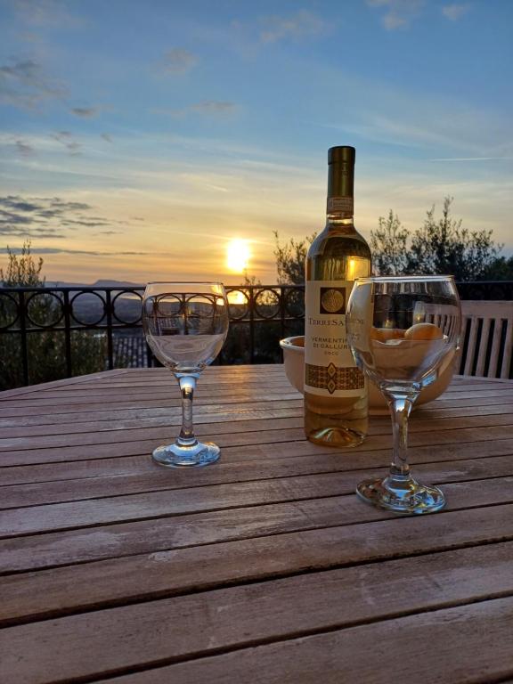 バデージにあるSunset View Apartment and Pool Badesiの木製テーブルにワイン1本とグラス2杯