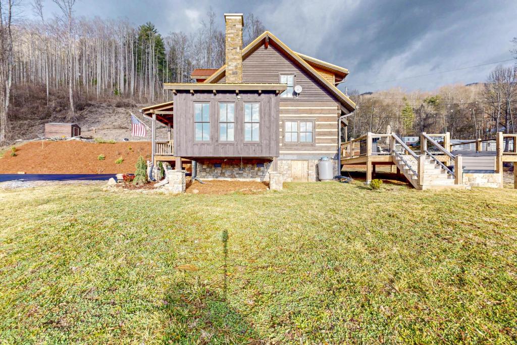 una casa en una colina con un patio en Moss Creek Cabin, en Sylva
